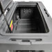 Image of the open interior of a grey storage box, showing a drain hole and tie-down points, angled top view on a white background.