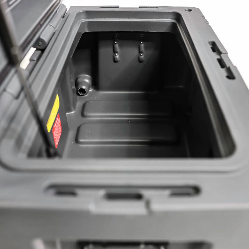 Image of the open interior of a grey storage box, showing a drain hole and tie-down points, angled top view on a white background.
