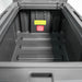 Image of the open interior of a dark gray storage box, showcasing the ribbed bottom and warning labels, direct top view on a white background.