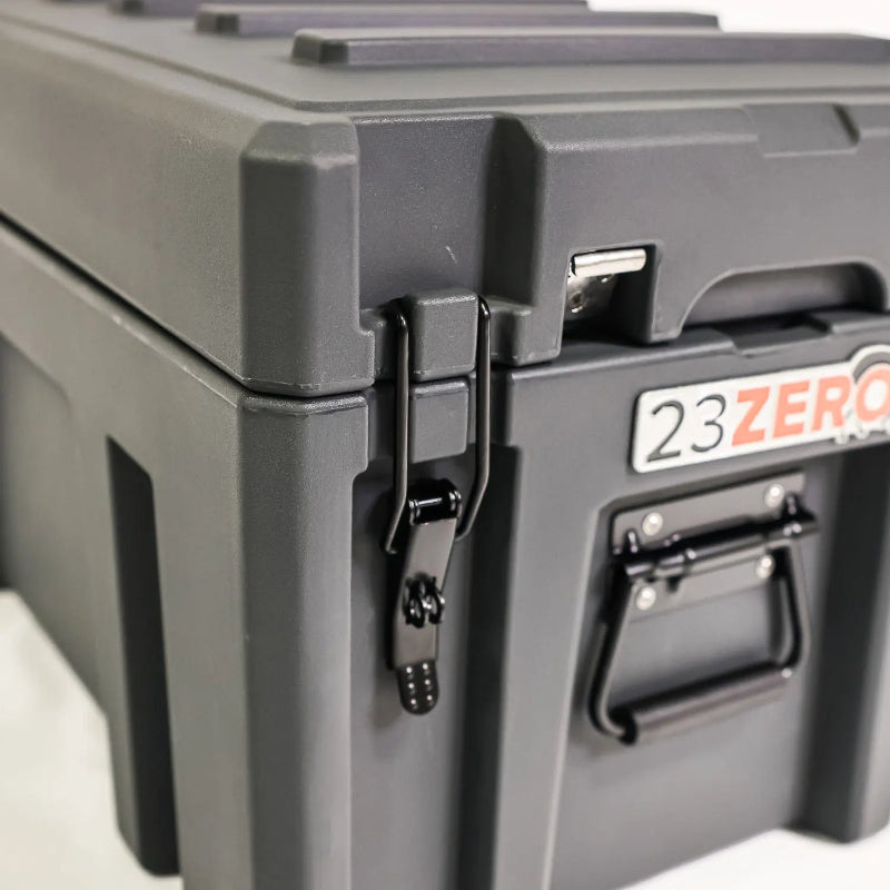 Image of a close-up of a black latch and handle on a dark gray 23ZERO storage box, angled side view on a white background.