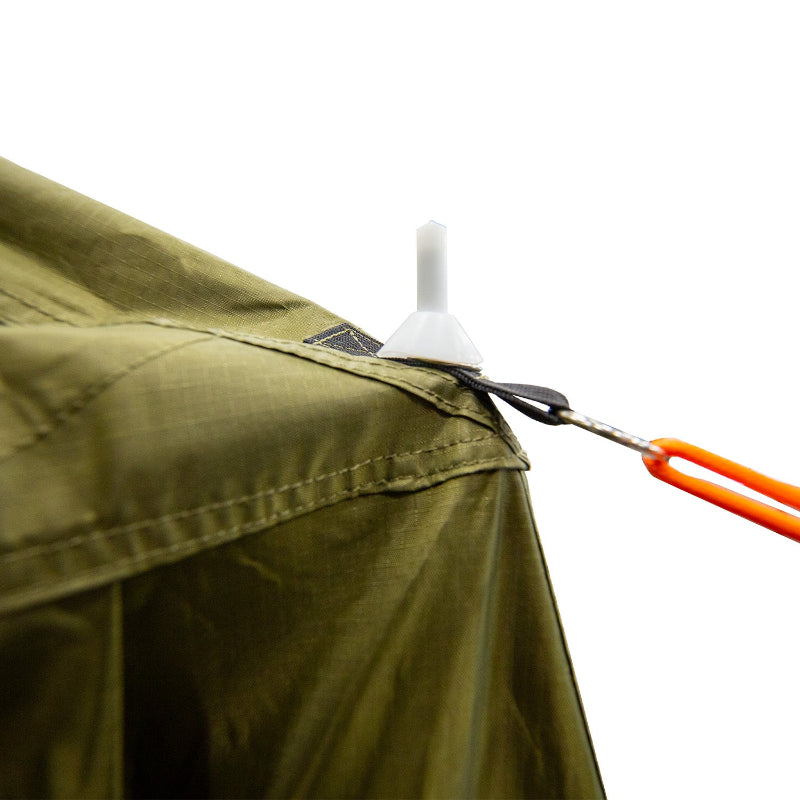 Image of a close-up detail of the 23ZERO Armadillo A2 Plus rooftop tent annex room, showing a guy rope with an orange tensioner attached to a plastic stake on the green fabric. The close-up shot focuses on the detailed attachment point