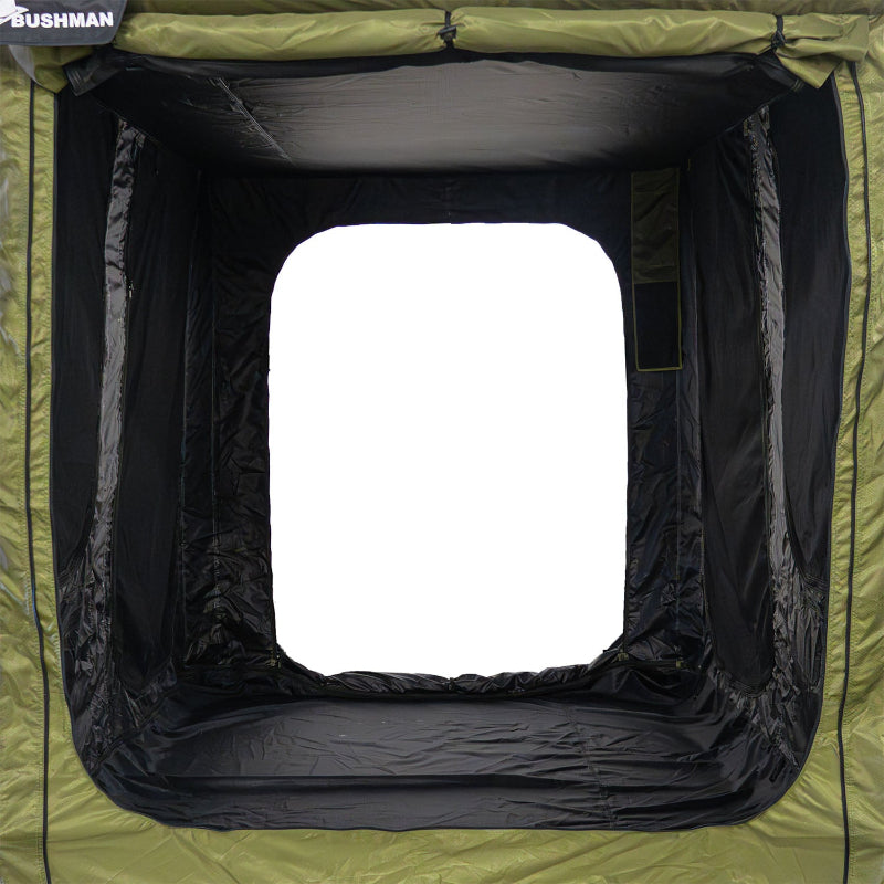 Image of the inside of a 23ZERO Bushman 78 Awning room, with the large front opening visible. The view from inside shows the green outer fabric with a black underside