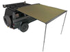 Image of a green Peregrine Awning partially deployed, extending from the side of a dark green Nissan SUV. The awning is supported by two black poles, providing shade, and is shown against a white background