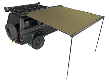 Image of a green Peregrine Awning partially deployed, extending from the side of a dark green Nissan SUV. The awning is supported by two black poles, providing shade, and is shown against a white background