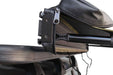 Close-up image of a rolled-up Peregrine Awning attached to a roof rack, highlighting the black zipper with an "SSS" pull tab and the bundled green fabric. The image focuses on the attachment mechanism and the compact storage of the awning against a white background