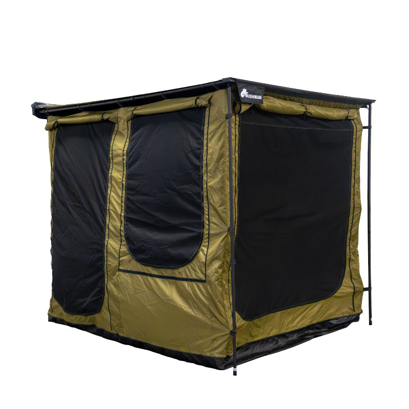 Image of a fully deployed Bushman awning room featuring green fabric and prominent black mesh windows on the front and side. The awning room is presented from an angled front and side view on a white background