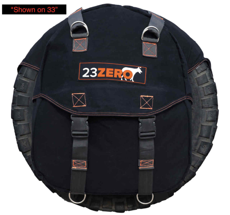 Image of a black canvas 23ZERO spare tire storage bag with orange stitching and grey straps, mounted on a 33-inch tire, showcasing the front with buckles and D-rings on a white background.