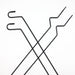 Image of black steel awning window pole mounts with bent hook ends, crossed layout top view on white background.