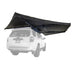 Image of the black 23ZERO Peregrine Pro 270-degree awning fully deployed and mounted to the roof rack of a white SUV, shown from a low rear-angled perspective on a white background