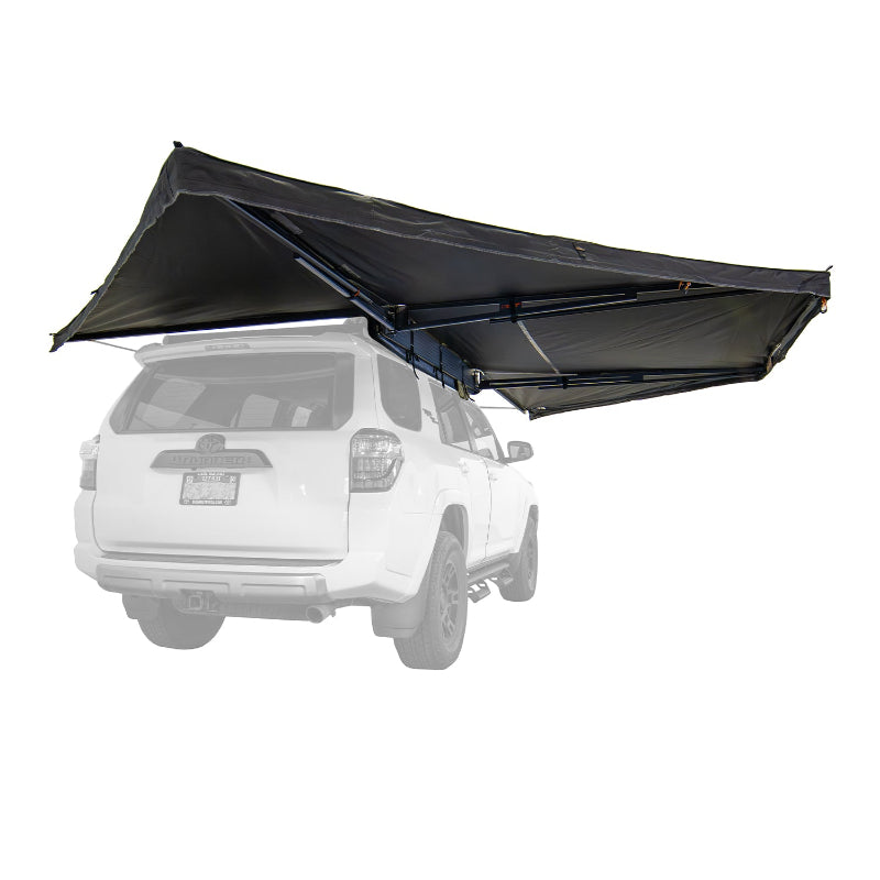 Image of the black 23ZERO Peregrine Pro 270-degree awning fully deployed and mounted to the roof rack of a white SUV, shown from a low rear-angled perspective on a white background