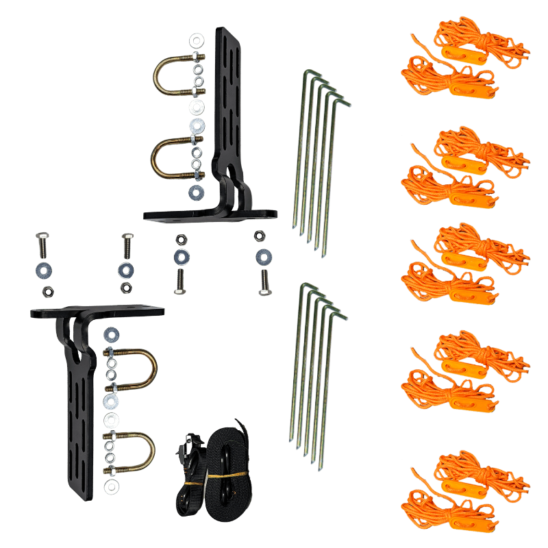 Image of complete awning mounting and tie-down kit arranged flat, including black metal brackets with U-bolts and hardware, steel ground stakes, orange guy ropes with tensioners, and black straps, top-down view on a solid background.