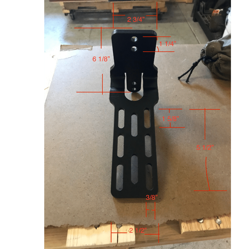 Image of black metal awning mounting bracket with elongated slotted holes and bolt points, shown with red measurement annotations indicating detailed dimensions, front-facing view on a cardboard background.