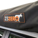 Image of a close-up detail of the 23ZERO brand logo on the black carrying case of the Peregrine PRO 180 Awning. The logo is a black and orange patch with the text "23ZERO" and a stylized wolf head