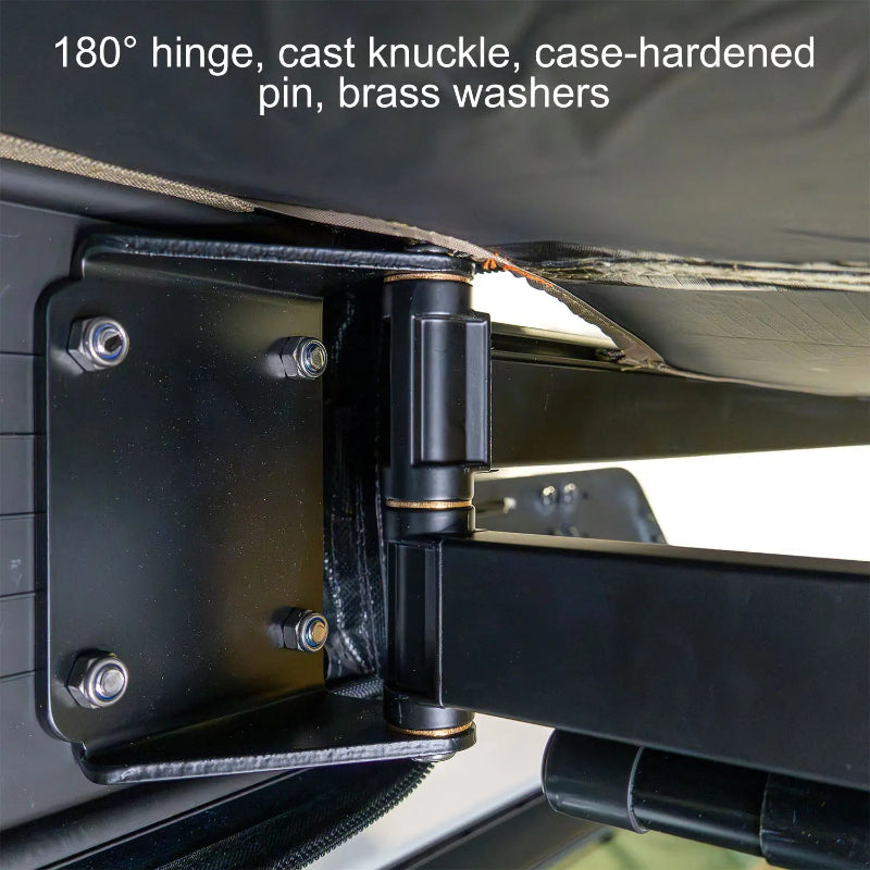 Image of a close-up view of the heavy-duty hinge and knuckle assembly of a 23ZERO Peregrine Awning. The black metal hardware, secured with bolts, features a case-hardened pin and brass washers for durability and smooth operation