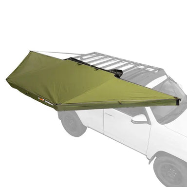 Image of a 23ZERO Peregrine 180 Compact Awning partially deployed with its green fabric unfurled, mounted to a vehicle roof rack. The vehicle is faded to a white background to highlight the product