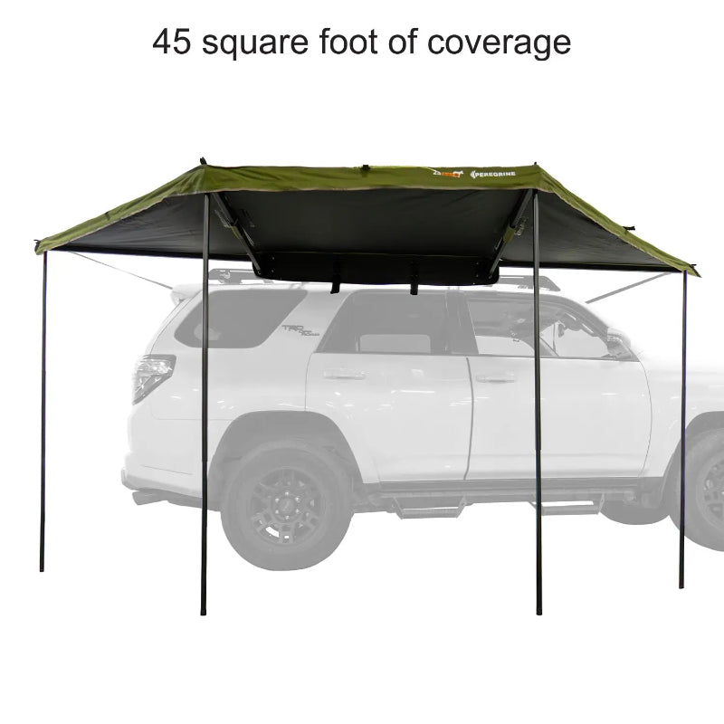 Image of a 23ZERO Peregrine 180 Compact Awning fully deployed from the rear of a vehicle, providing 45 square feet of coverage. The awning's green fabric with a black underside is supported by black poles, creating a shaded area behind a white vehicle