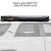 Image of a 23ZERO Peregrine 180 Compact Awning enclosed in its heavy-duty black 600D PVC transit cover. The zipped and rolled-up awning is mounted on a vehicle's roof rack, shown from a side profile view