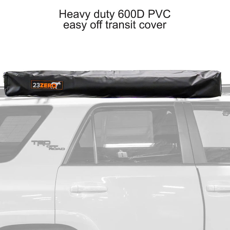 Image of a 23ZERO Peregrine 180 Compact Awning enclosed in its heavy-duty black 600D PVC transit cover. The zipped and rolled-up awning is mounted on a vehicle's roof rack, shown from a side profile view