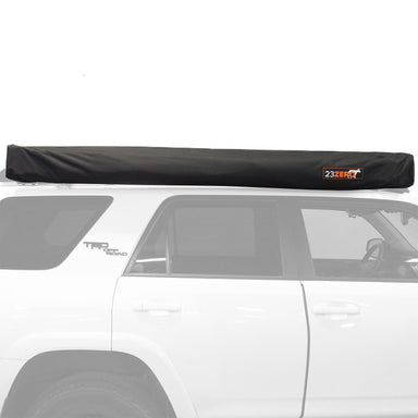 Image of 23Zero Peregrine Pro 270° 5-arm awning in its closed transit cover, black fabric with 23Zero logo, mounted on the roof of a white vehicle, side view with vehicle silhouette
