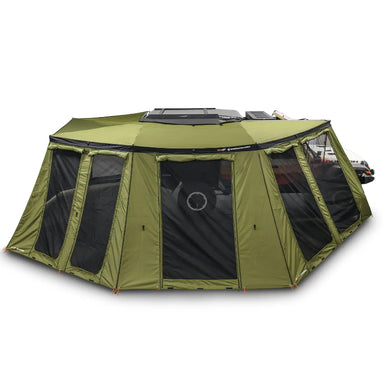 Image of an OVS Peregrine Pro 270-degree awning with all walls deployed, creating a large olive green enclosure, attached to a vehicle and set against a white background