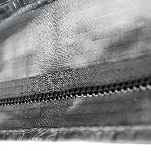 Close-up image of interior fabric with zipper detail on Peregrine Pro 5-arm awning, black fabric with textured surface, detailed shot on white background