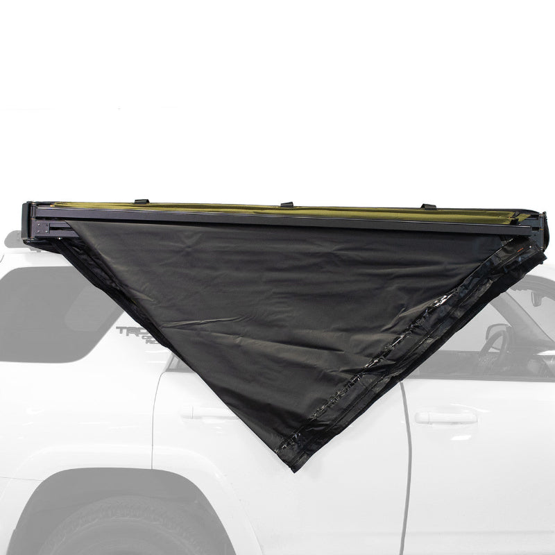 Image of Peregrine Pro 5-arm awning partially deployed, black fabric with green underside, angled side view on vehicle with white background