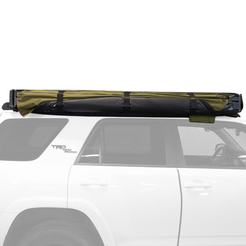 Image of Peregrine Pro 5-arm awning rolled up on white vehicle, black and green fabric, side view on white background