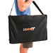 Image of 23ZERO camping table carry bag with shoulder strap and orange trim, black fabric rectangular case shown over shoulder on white background.