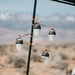 Image of 23ZERO universal 2-way lantern hooks with orange coated steel arms holding camping lights on tent pole, outdoor campsite view.