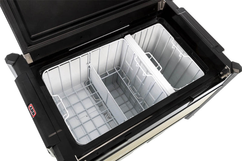 Image of ARB Zero Fridge Freezer with the lid open, showing two compartments with wire dividers and white plastic inserts, angled top-down view on a white background.