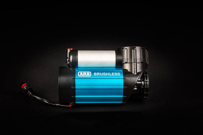 Image of an ARB Brushless 12V Air Compressor, blue and silver, with wiring, viewed from the side on a black background
