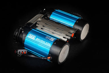 Image of a blue and black ARB Brushless air compressor with a silver mounting bracket, angled on a dark background
