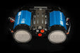 Image of an ARB Brushless Twin Air Compressor, featuring blue heat sinks and a black central manifold with orange ports, viewed from above on a dark background