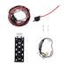 Image showing four components: a coiled red and black wiring harness, a single red power cable with an inline fuse and ring terminal, a black metal mounting bracket, and a multi-colored wiring harness with switch labels, all on a white background
