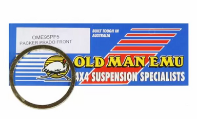 Image of Old Man Emu OME95PF5 front coil spring trim packer ring for Prado, circular spacer displayed in front of branded packaging on white background.