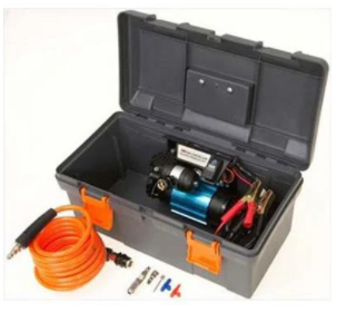 Image of an ARB Portable Air Compressor in an open gray toolbox with orange latches on a white background. The blue and black compressor is in the case with the orange air hose and fittings resting next to it