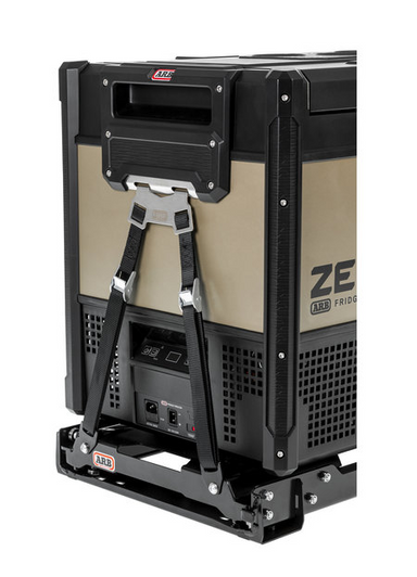 Image of ARB Zero Series portable fridge secured with tie-down mounting kit, black and tan fridge with straps and metal base, rear angled view on white background.