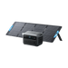 Image of Anker SOLIX portable power station placed in front of a foldable solar panel setup with integrated stand, digital display and AC outlets visible, rugged gray design, angled front view on black background.