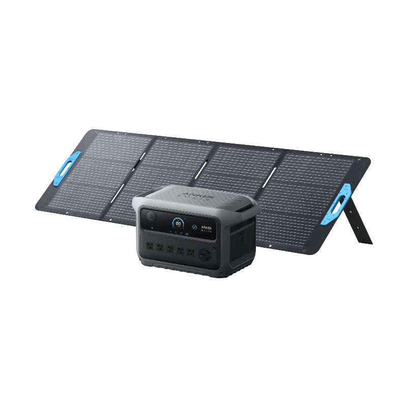 Image of Anker SOLIX portable power station placed in front of a foldable solar panel setup with integrated stand, digital display and AC outlets visible, rugged gray design, angled front view on black background.