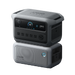 Image of Anker SOLIX portable power station stacked on expansion battery with illuminated control button, digital display and multiple AC outlets, rugged gray design, angled front and side view on black background.