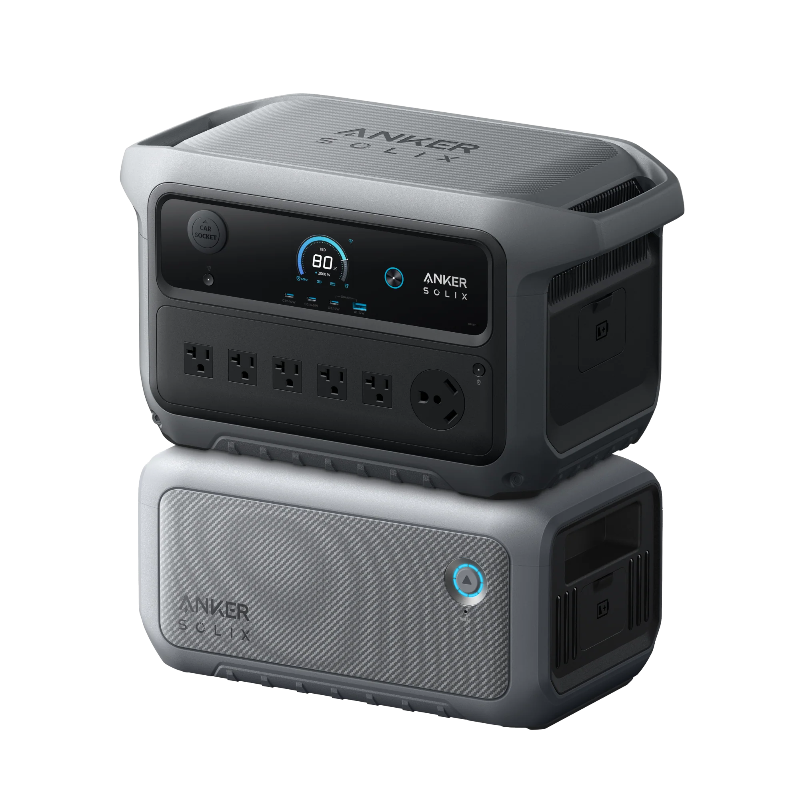 Image of Anker SOLIX portable power station stacked on expansion battery with illuminated control button, digital display and multiple AC outlets, rugged gray design, angled front and side view on black background.