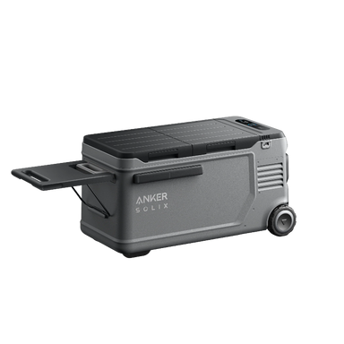 Image of Anker SOLIX EverFrost electric cooler with rugged gray body, closed lid, pull-out side tray, wheels and handle visible, angled front and side view on transparent background.
