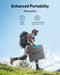 Image of Anker SOLIX portable solar panel folded for easy carrying, lightweight black panel with blue handle held by hiker with backpack, outdoor side view on grassy hillside background.