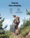 Image of Anker SOLIX portable solar panel folded for easy transport, lightweight black panel with blue handle carried by a hiker with backpack, rear angled view on outdoor trail background.