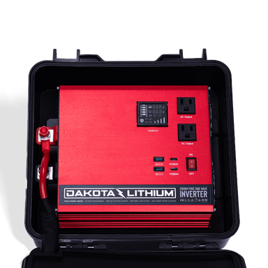 Image of an open Dakota Lithium Powerbox 135 revealing a red 2000W Pure Sine Wave Inverter with display, AC outputs, and USB ports, front view on a dark background