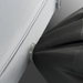 Image of the Dometic High-Rise sleeping pad's valve with a silver ring, connected to a black air pump bag, on a gray background.