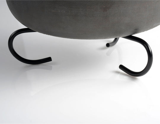 Image of GSI Dutch oven stand supporting cast iron pot base, close-up angled view on white background.