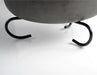 Image of GSI Dutch oven stand supporting cast iron pot base, close-up angled view on white background.