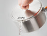 Image of a hand holding a GSI Outdoors Glacier Pot, with water actively straining out through the perforated lid, against a plain background.