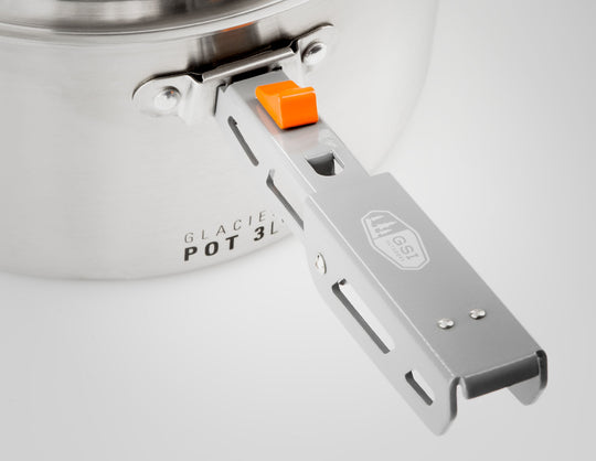 Close-up image of the GSI Outdoors pot gripper attached to the side of a 'Glacier Pot 3L,' featuring its orange release button and etched logo, against a white background.